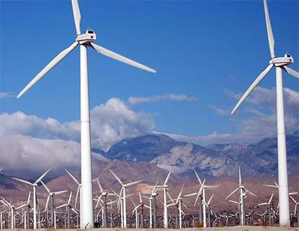 dozens of windmills next to mountain side